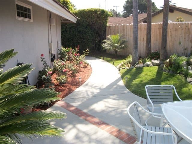 Curved concrete walkway with a red brick inlay edge