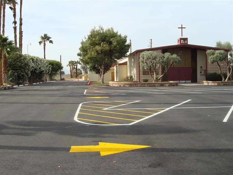 Parking lot with yellow directional arrows and ADA striping after restriping